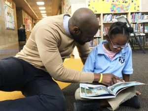 adam reads with girl