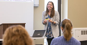 A Saint Michael's College alum stands in front of a group of students. 