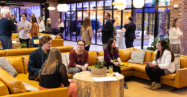 people chatting in groups sitting and standing at a networking reception