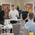 group of student researchers standing together speaking to people at tables