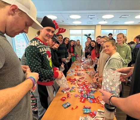 a group of students filling goodie bags with holiday treats
