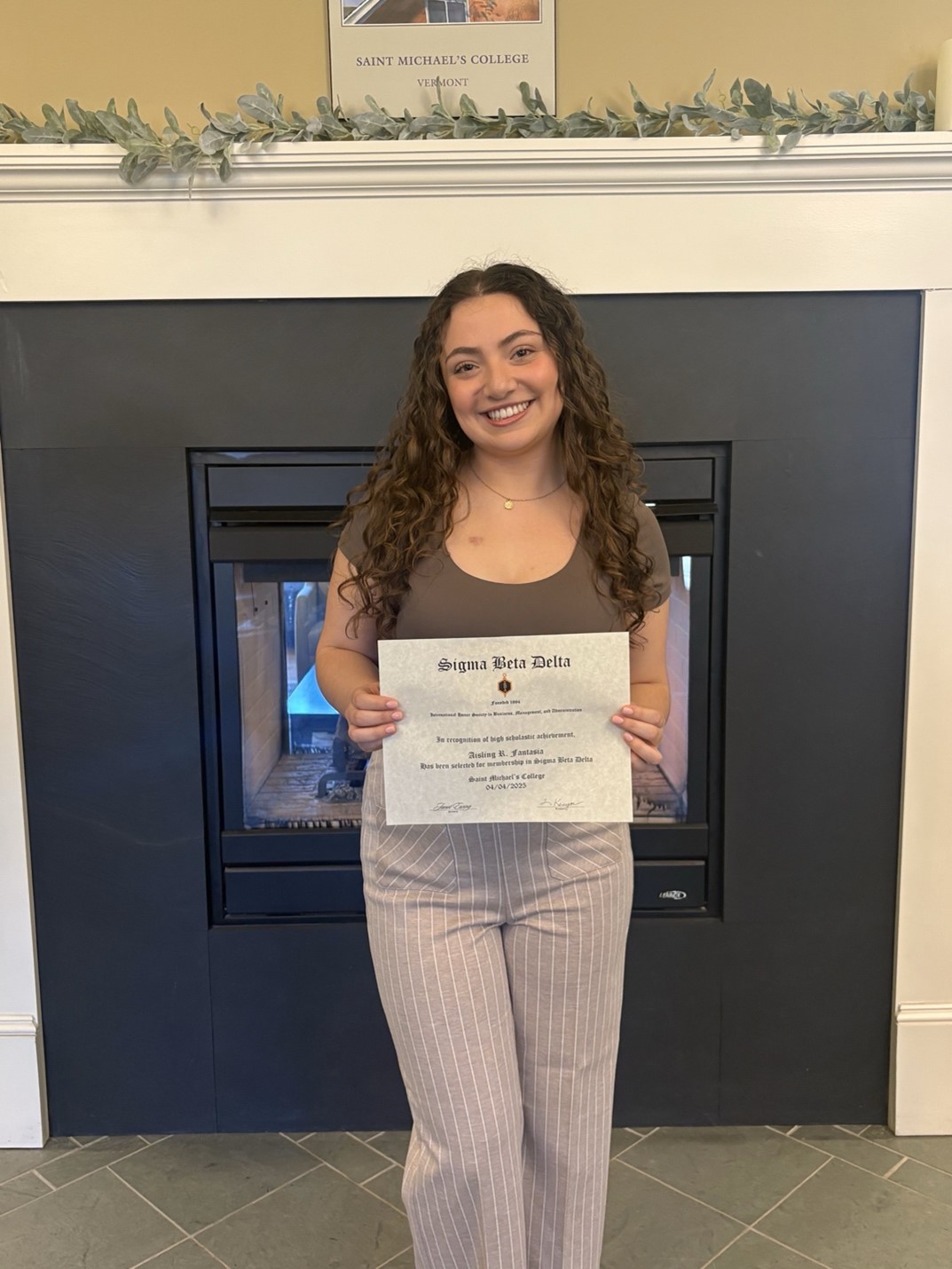 Aisling Fantasia poses with Sigma Beta Delta certificate