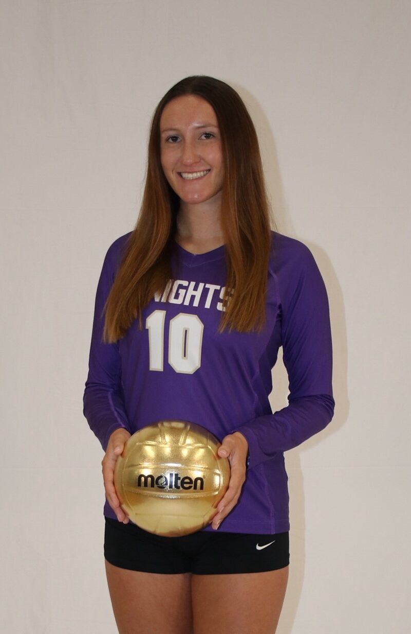 Dana Welch posing with a golden volleyball
