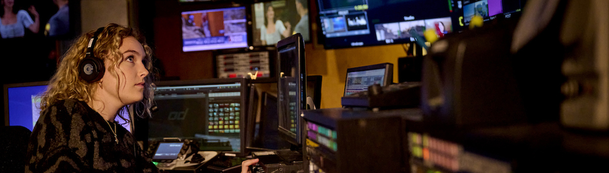 Female Saint Michael's College student at tv station switch board during her internship
