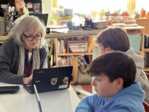 Meg O’Donnell '88 goes over what a student has written during a middle school Humanities class at Shelburne Community School. Photo by April Barton.