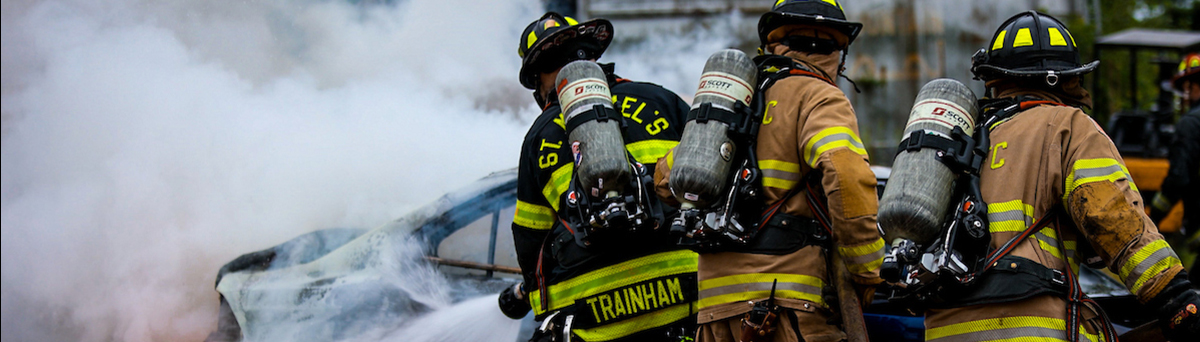 Firefighters put out a fire near a car during a live burn exercise