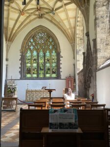 A woman peacefully praying in a small chapel in Wales