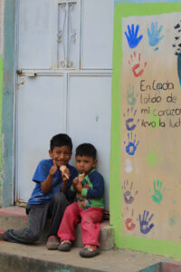 Two boys eating ice cream outside their classroom in Guatemala