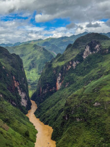 A winding river between towering green mountains in Vietnam