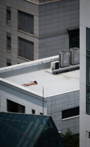 A man basking in the sun atop one of Gangnam’s many high-rise buildings.