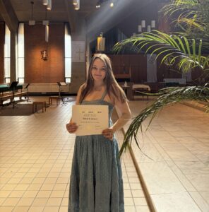 Ashley Silveira poses with a certificate of induction into an honor society.