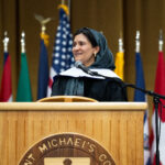 An Afghan woman gives a speech at a podium.